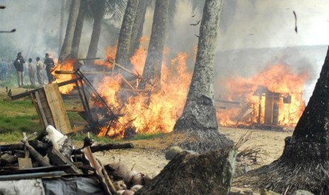   Sejumlah warga bersama Satpol PP Kota Padang membakar pondok yang diduga tempat maksiat di kawasan Bukit Lampu, Padang, Sumbar, Selasa (29/5). (Maril Gafur/Antara)