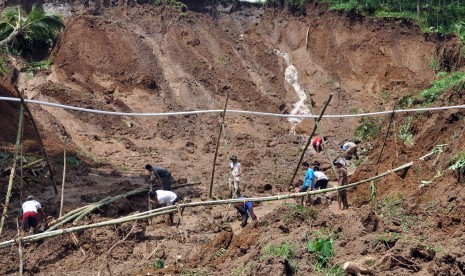 Sejumlah warga bersama tim SAR, anggota TNI dan polisi menyingkirkan timbunan tanah longsor yang menutup jalan antar desa di kawasan lereng gunung Sumbing Desa Kalegen, Bandongan, Magelang, Jawa Tengah, Selasa (15/12).