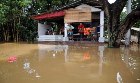  Sejumlah warga bertahan di lantai dua rumahnya yang terendam luapan air Sungai Ciliwung di Jalan H Bawah, Kelurahan Kebon Baru, Kecamatan Tebet, Jakarta Selatan, Rabu (22/1).  (Republika/Prayogi)