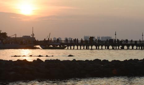 Sejumlah warga berwisata di Dermaga Pantai Ancol, Jakarta, Sabtu (18/6/2022). ]