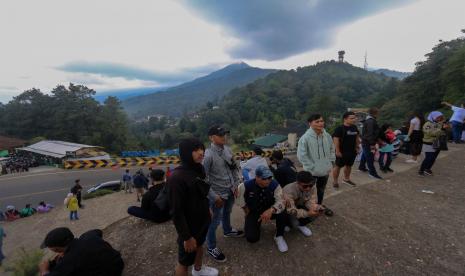 Sejumlah warga berwisata di tebing Puncak Pass, Cianjur, Kabupaten Bogor, Jawa Barat, Sabtu (7/5/2022). Tebing buatan yang berada di pinggir jalan itu menjadi salah satu tujuan wisata alternatif bagi wisatawan saat menunggu kemacetan. Kunjungan Wisatawan ke Selatan Cianjur Meningkat