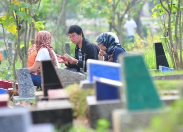 Sejumlah warga berziarah ke makam saudara mereka di Tempat Pemakaman Umum (TPU) Karet, Jakarta, Ahad (17/7). Menjelang Ramdhan sejumlah TPU di Jakarta dan berbagai daerah lainnya mengalami peningkatan peziarah.