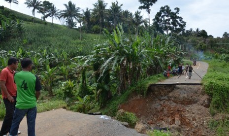 Sejumlah warga dan kendaraan tidak dapat melintas akibat jalan ambles di Desa Puncak Mandiri, Sumalata, Kabupaten Gorontalo Utara, Gorontalo, Sabtu (25/2).