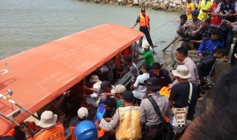 Sejumlah warga dan tim SAR berusaha mengevakuasi salah seorang korban tenggelamnya KM Marina di Pelabuhan Tobaku Kolaka Utara, Sulawesi Tenggara, Minggu (20/12). 