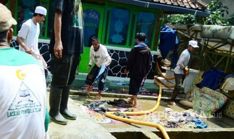 Sejumlah warga dibantu relawan membersihkan pelengkapan masjid dan pakaian yang sempat terendam banjir. (Ilustrasi)