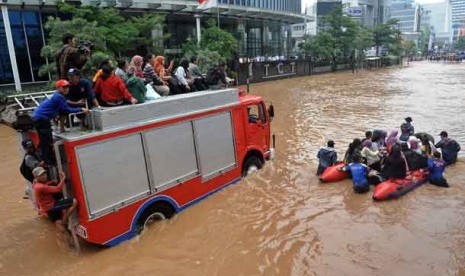  Sejumlah warga dievakuasi dengan menggunakan perahu karet dan mobil pemadam kebakaran ketika banjir melanda kawasan Jl. Sudirman, Jakarta, Kamis (17/1).