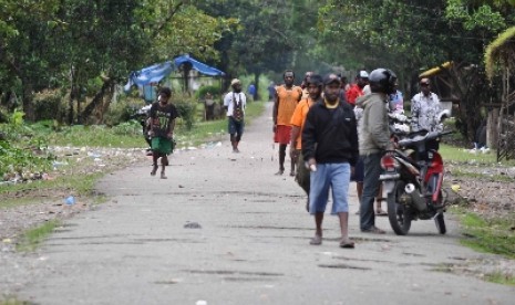   Sejumlah warga duduk dan berjalan di lokasi pertikaian dua kelompok warga di Kwamki Lama, Timika, Papua (ilustrasi). 