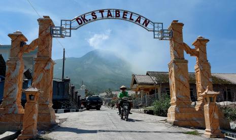   Sejumlah warga Dukuh Stabelan, Desa Tlogolele, Kecamatan Selo, Kabupaten Boyolali, Jawa Tengah, masih beraktivitas normal dengan latar belakang puncak Gunung Merapi, Ahad (12/3). Mereka diimbau tetap siaga dan mewaspadai aktivitas vulkanik terkini Merapi.