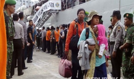 Sejumlah warga eks anggota Gafatar menuruni tangga KRI Gili Manuk beberapa saat setelah tiba di Pelabuhan Tanjung Emas Semarang, Senin (25/1). (Republika/Bowo Pribadi)