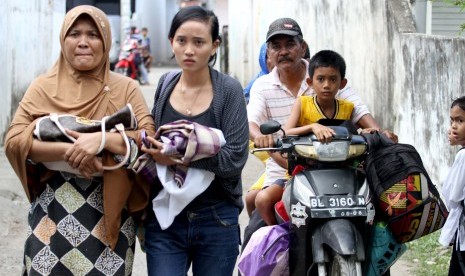 Sejumlah warga Kampung Jawa Lama berlarian keluar rumah menyelamatkan diri setlah mendengar isu tsunami pasca gempa melanda Lhokseumawe, Provinsi NAD, Rabu (11/4).