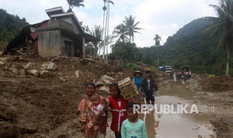 Enam Kabupaten/Kota di Sumsel Rawan Longsor. Sejumlah warga korban banjir bandang membawa bantuan di desa Sapan, Kecamatan Koto Parik Gadang di Ateh, Kabupaten Solok Selatan, Sumatra Barat. 