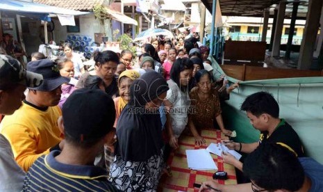   Sejumlah warga kurang mampu antre untuk mendapatkan kupon penukaran sembako murah di Pademangan Jakarta Utara, Kamis (1/8).     (Republika/Agung Supriyanto)