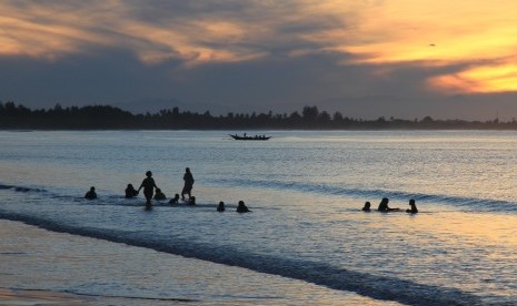 Sejumlah warga mandi sambil menikmati suasana matahari terbit awal tahun 2019 di kawasan objek wisata pantai Desa Gampong Teungoh, Samatiga, Aceh Barat, Aceh, Selasa (1/1/2019). 