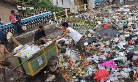 Sejumlah warga melakukan aksi dengan menumpahkan sampah ke Jalan Ciwalen, Kabupaten Garut, Jawa Barat, Jumat (15/11).