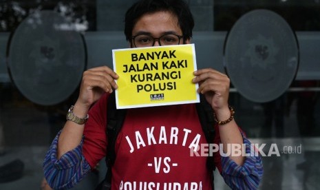 Sejumlah warga melakukan aksi mengawal sidang perdana gugatan terkait polusi udara Jakarta di Pengadilan Negeri Jakarta Pusat, Jakarta, Kamis (1/8/2019).