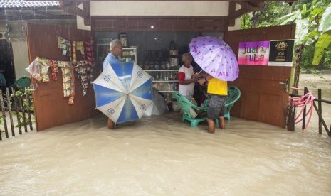 Sejumlah warga melakukan aktivitas jual beli ketika banjir menggenangi pemukiman di Desa Gotakan, Panjatan, Kulon Progo, Yogyakarta, Jumat (20/12).   (Antara/Sigid Kurniawan)