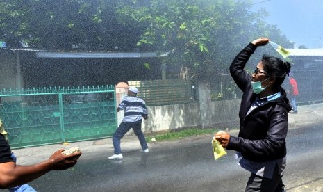 Sejumlah warga melemparkan bensin ke arah polisi saat terjadi bentrokan eksekusi rumah dinas TNI di Kompleks Buntu Torpedo Makassar, Sulawesi Selatan, Kamis (3/12).  (Antara/Yusran Uccang)