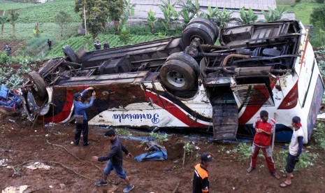 Sejumlah warga melihat bus yang jatuh akibat terlibat kecelakaan beruntun di Jalan Puncak, Ciloto, Cipanas, Cianjur, Jawa Barat, Minggu (30/4).