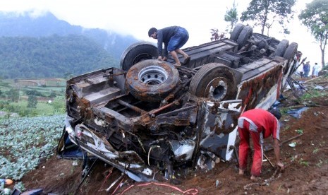 Sejumlah warga melihat bus yang jatuh akibat terlibat kecelakaan beruntun di Jalan Puncak, Ciloto, Cipanas, Cianjur, Jawa Barat, Minggu (30/4). 