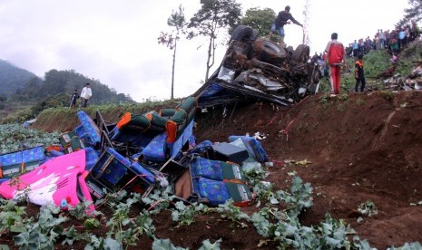 Sejumlah warga melihat bus yang jatuh akibat terlibat kecelakaan beruntun di Jalan Puncak, Ciloto, Cipanas, Cianjur, Jawa Barat, Ahad (30/4). 