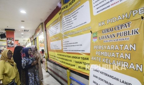 Sejumlah warga melihat papan informasi di Gerai Cepat Layanan kependudukan di Sentra Grosir Cikarang (SGC) di Kabupaten Bekasi, Jawa Barat, Jumat (1/11/2019). 