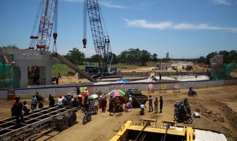 Sejumlah warga melihat tim Laboratorium Forensik Polda Jatim melakukan penyelidikan di lokasi girder proyek Strategis Nasional (PSN) Tol Pasuruan - Probolinggo (Paspro) yang ambruk di Desa Cukurgondang, Grati, Pasuruan, Jawa Timur, Senin (30/10).