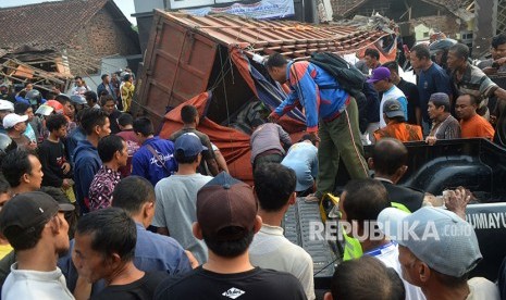 Sejumlah warga melihat truk yang mengalami kecelakaan di jalur tengah Tegal-Purwokerto, Desa Jatisawit, Bumiayu, Brebes, Jawa Tengah, Minggu (20/5).