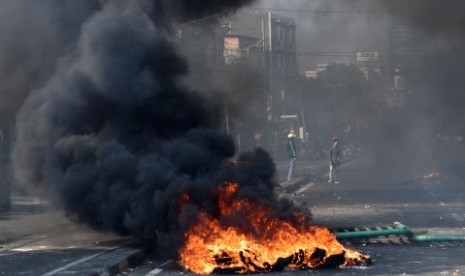 Sejumlah warga melintasi ban yang dibakar di tengah Jalan KS. Tubun, Petamburan, Jakarta Pusat, Rabu (22/5/2019). 