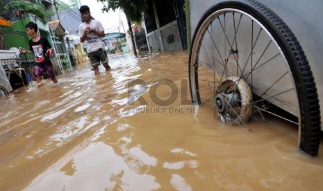   Sejumlah warga melintasi banjir di Jalan Kampung Melayu Kecil,Jakarta Timur, Selasa ( 5/3).  (Republika/Prayogi)