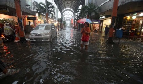 Sejumlah warga melintasi banjir di kawasan Pasar Baru, Jakarta, Senin (9/2).(ANTARA/Zabur Karuru)