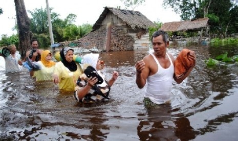   Sejumlah warga melintasi genangan banjir di Desa Pasie Masjid, Kecamatan Merebou, Kabupaten Aceh Barat (ilustrasi).