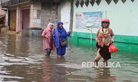 Sejumlah warga melintasi jalan yang terimbas banjir di wilayah Kelurahan Duren Jaya Kecamatan Bekasi Timur Kota Bekasi, Kamis (15/2).