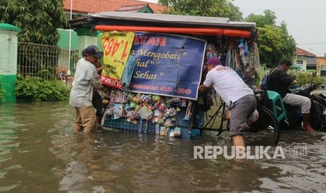 Sejumlah warga melintasi jalan yang terimbas banjir di wilayah Kelurahan Duren Jaya Kecamatan Bekasi Timur Kota Bekasi, Kamis (15/2).