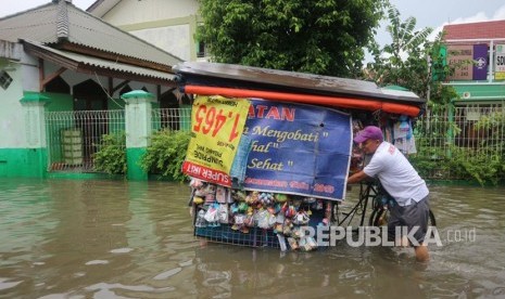 Sejumlah warga melintasi jalan yang terimbas banjir di wilayah Kelurahan Duren Jaya Kecamatan Bekasi Timur Kota Bekasi, Kamis (15/2).