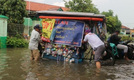 Sejumlah warga melintasi jalan yang terimbas banjir di wilayah Kelurahan Duren Jaya Kecamatan Bekasi Timur Kota Bekasi, Kamis (15/2).