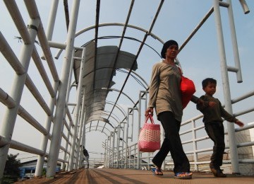 Sejumlah warga melintasi jembatan penyebrangan orang (JPO) tanpa atap di Jakarta, Sabtu (31/3). (Republika/Agung Fatma Putra)