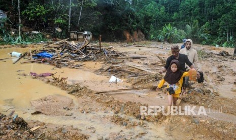 Sejumlah warga melintasi pemukiman yang rusak terdampak banjir bandang di Kampung Panggeleseran, Desa Citorek Kidul, Lebak, Banten, Ahad (8/12/2019).