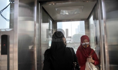 Sejumlah Warga memanfaatkan lift untuk menuju jembatan yang menghubungkan halte busway di Halte Busway Tosari, Jakarta Pusat, Senin (18/5). 