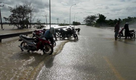 Sejumlah warga memarkir sepeda motor di Km 59 jalan tol Jakarta - Merak, Cikande, Serang, Banten, Kamis (10/1).