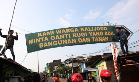 Sejumlah warga memasang spanduk yang bertuliskan tuntutan ganti rugi atas penertiban permukiman di Kalijodo, Jakarta Utara, Kamis (18/2). 