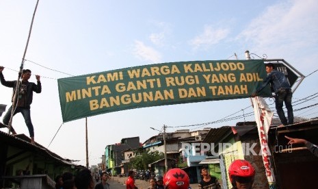 Sejumlah warga memasang spanduk yang bertuliskan tuntutan ganti rugi atas penertiban permukiman di Kalijodo, Jakarta Utara, Kamis (18/2).