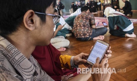 Sejumlah warga membaca Alquran digital Quran Best di gawainya usai acara Peluncuran aplikasi Quran Best di Masjid Al Ukhuwah, Jalan Wastukancana, Kota Bandung, Rabu (8/5). 