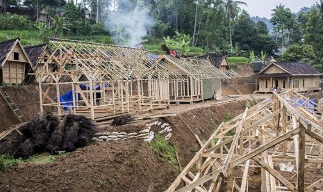 Sejumlah warga membangun kembali rumah adatnya pasca longsor yang terjadi di Kampung Cimapag, Desa Sinarresmi, Cisolok, Kabupaten Sukabumi, Jawa Barat, Rabu (6/3/2019).