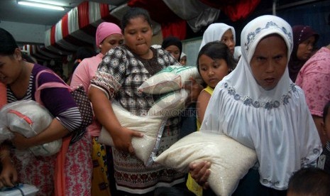 Sejumlah warga membawa beras hasil pembagian zakat yang dilaksanakan di Masjid Istiqlal, Jakarta Pusat, Ahad (27/7). (Republika/Raisan Al Farisi)