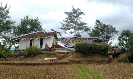 Sejumlah warga membersihkan rumah ambruk di lokasi bencana pergerakan tanah di Desa Waringinsari, Kecamatan Takokak, Cianjur, Jawa Barat, Selasa (3/10).