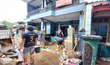 Sejumlah warga membersihkan rumah yang terdampak banjir bandang di Kampung Dayeuh Handap, Kelurahan Kota Kulon, Kecamatan Garut Kota, Kabupaten Garut. Menteri BUMN Erick Thohir memanjatkan doa dan menyampaikan simpatinya untuk para korban banjir di sejumlah daerah. Erick Thohir mengaku prihatin terhadap sejumlah daerah yang mengalami banjir akibat tingginya curah hujan.