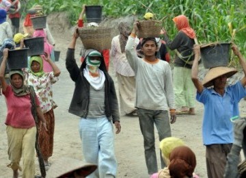 Sejumlah warga membersihkan sisa timbunan material vulkanik yang mengendap di jalanan dan selokan kawasan lereng Merapi.