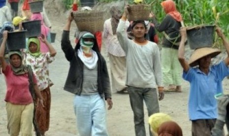 Sejumlah warga membersihkan sisa timbunan material vulkanik yang mengendap di jalanan dan selokan kawasan lereng Merapi.