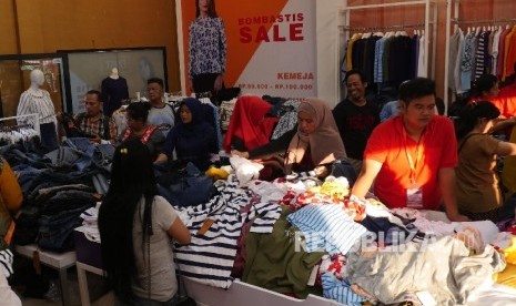  Sejumlah warga memilih berbagai baju yang didiskon di area Pekan Raya Jakarta (PRJ), Selasa (13/6).