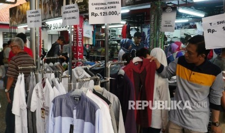  Sejumlah warga memilih berbagai baju yang didiskon di area Pekan Raya Jakarta (PRJ), Selasa (13/6). 